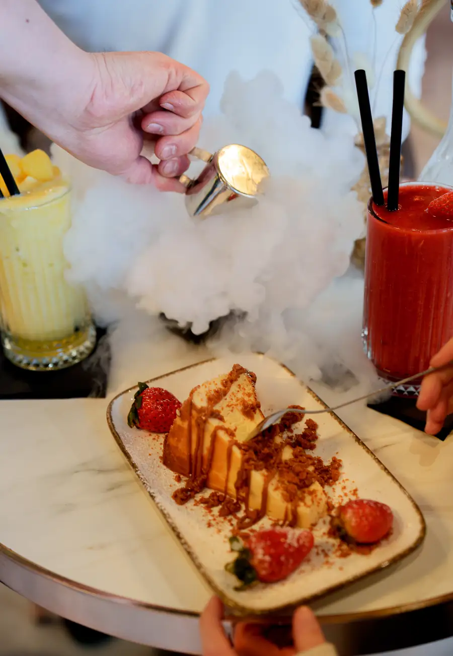 Dessert mit Erdbeeren und alkoholfreien Drinks am Tisch im The Leaf