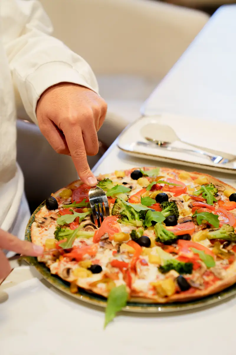 Frisch servierte Pizza mit Rucola auf einem Tisch im The Leaf