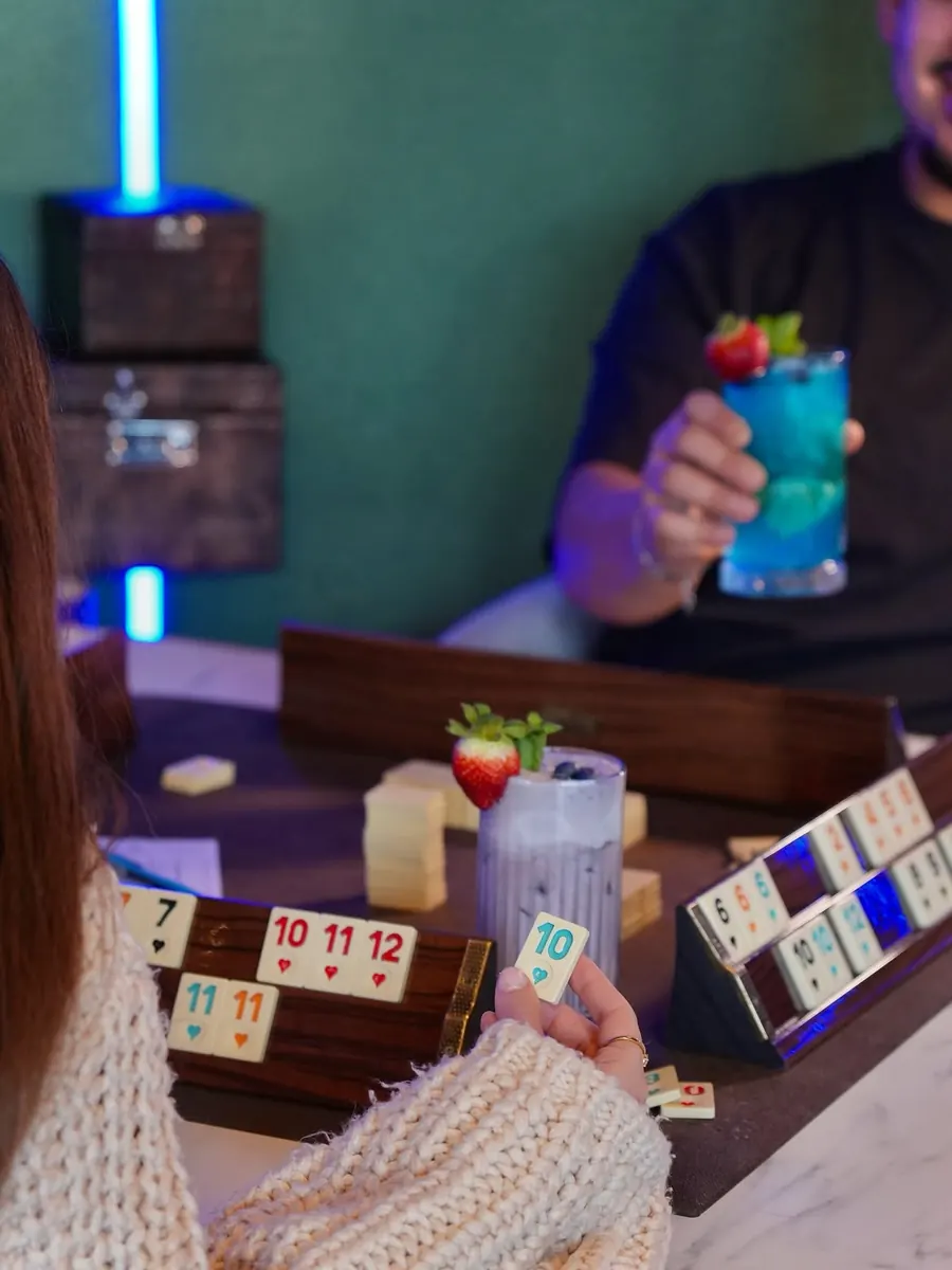 Freunde spielen Okey mit bunten Drinks im The Leaf